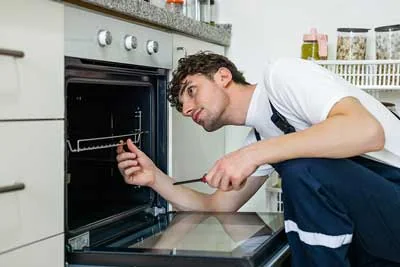 Independent appliance service professional checking the inside of a residential oven