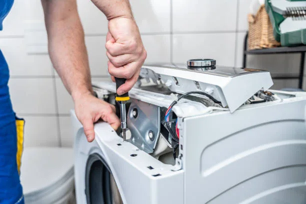 Close-up of an independent appliance service professional accessing washing machine controls