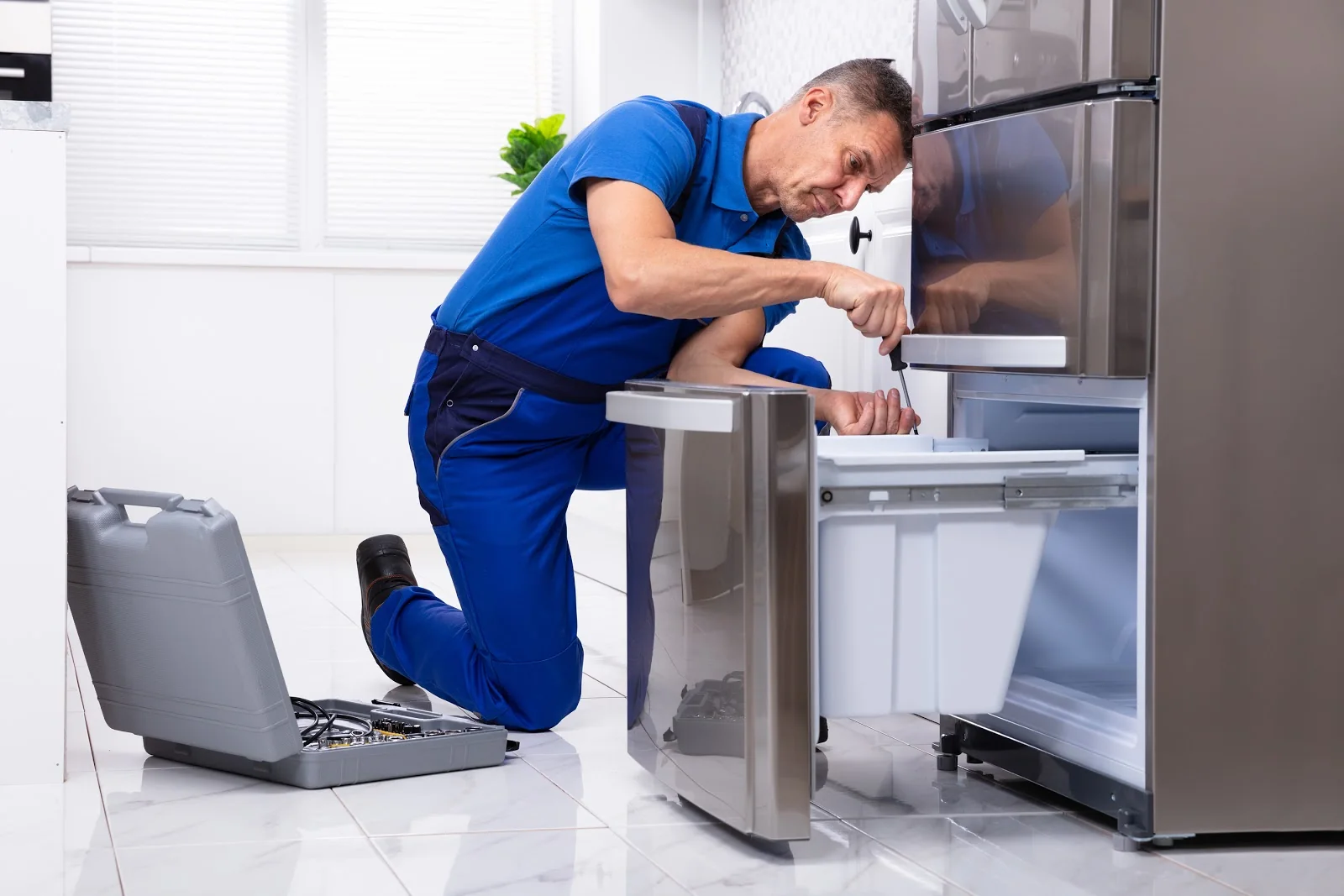 Independent appliance service professional inspecting a residential refrigerator