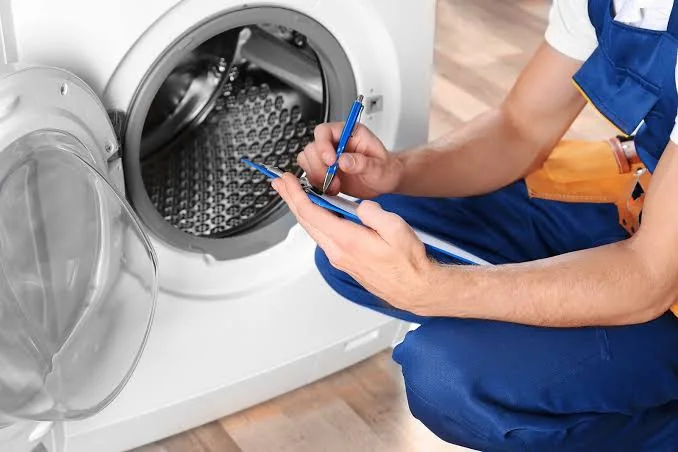 Independent appliance service professional documenting a washing machine inspection